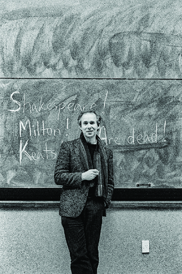 photo of the poet Bill Manhire in the early 1990s standing at a blackboard